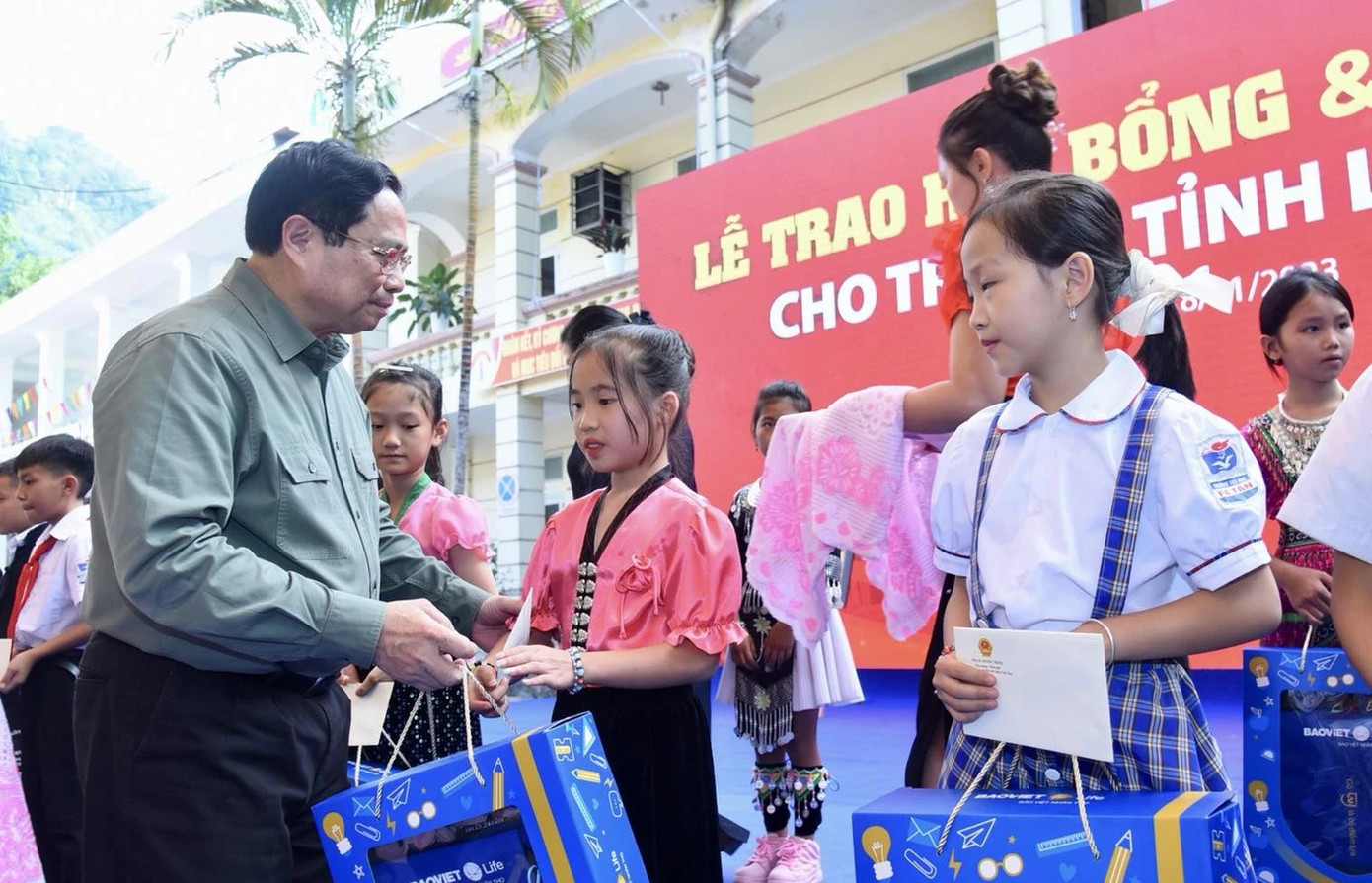 Thủ tướng Chính phủ Phạm Minh Chính tặng quà cho các học sinh. (Ảnh: Báo Nhân dân)