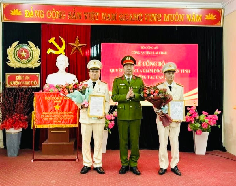 Đại tá Phạm Hải Đăng - Phó Giám đốc Công an tỉnh Lai Châu trao quyết định bổ nhiệm, tặng hoa chúc mừng Thiếu tá Phàn A Tủa và Thiếu tá Hoàng Văn Nam.