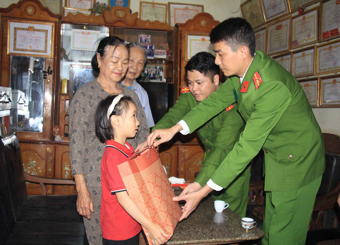 Thượng úy Nguyễn Văn Tùng (đầu tiên bên phải) cùng cán bộ Phòng Cảnh sát kinh tế thăm hỏi, tặng quà cho "Em nuôi của Đoàn".