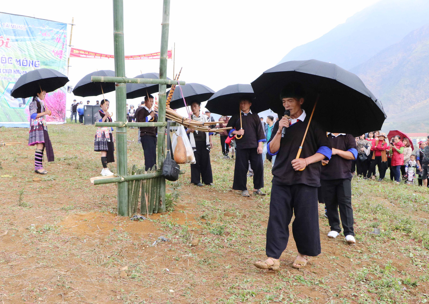 Ông chủ lễ cùng những người hát hội xoè ô đen che đầu đi vòng quanh gốc nêu. Vừa đi, họ vừa hát bài ca “Hán Ăn Tết - Mông Ăn Tết”.