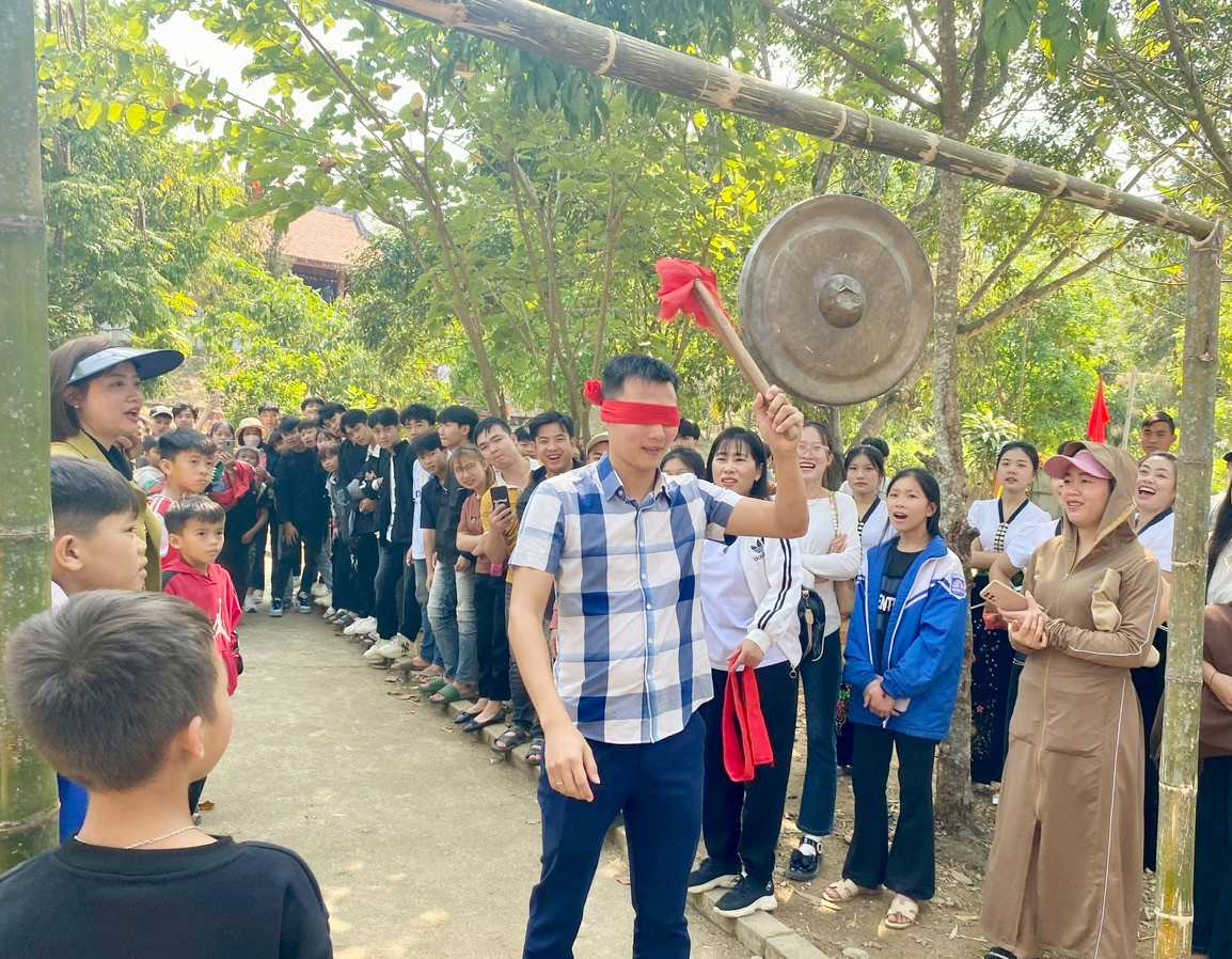 Du khách tham gia trò bịt mắt đánh chiêng.