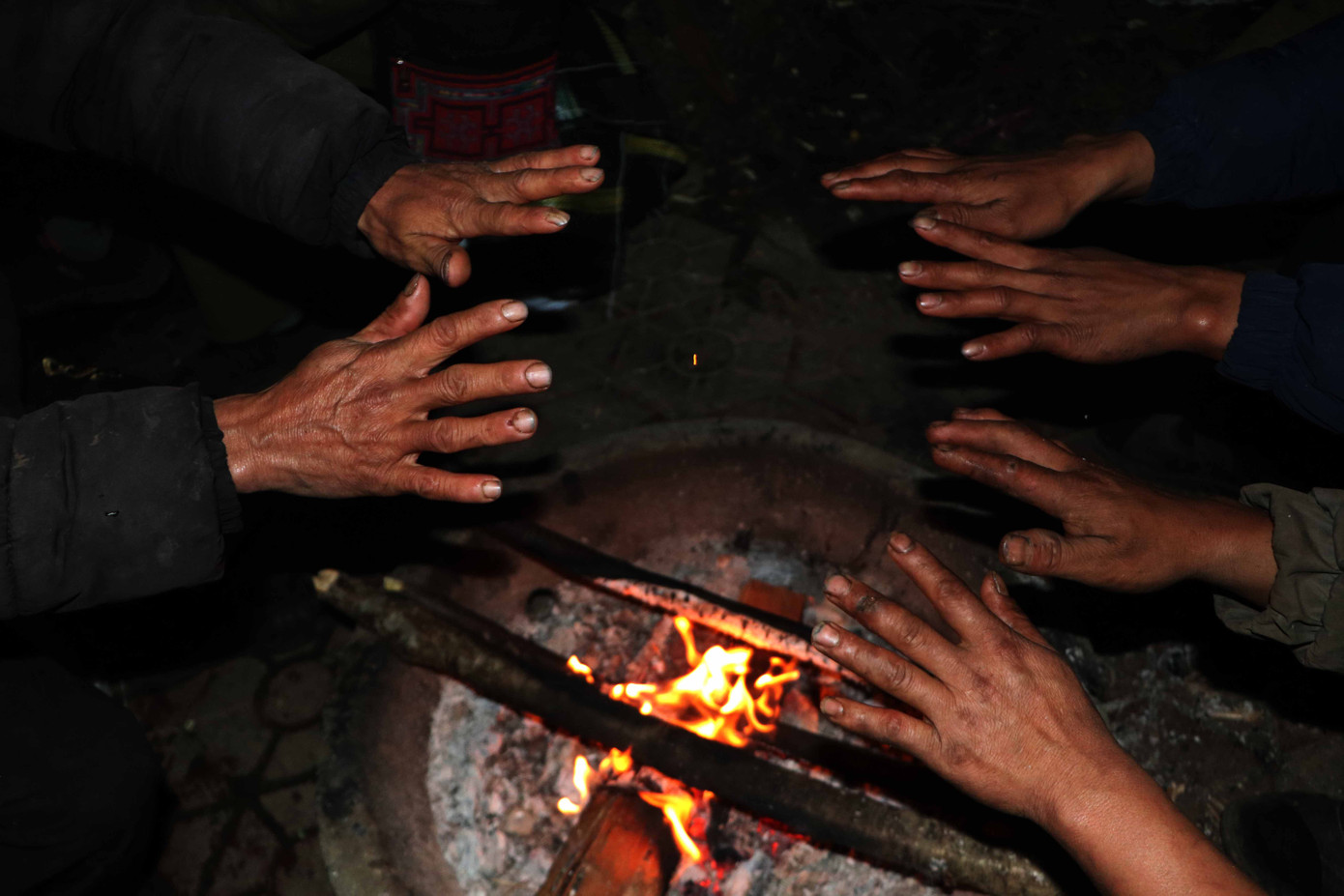 Khi thời gian gần đến giữa đêm, người dân quây quần sưởi ấm bên bếp lửa để xua đi cái rét lạnh buốt.