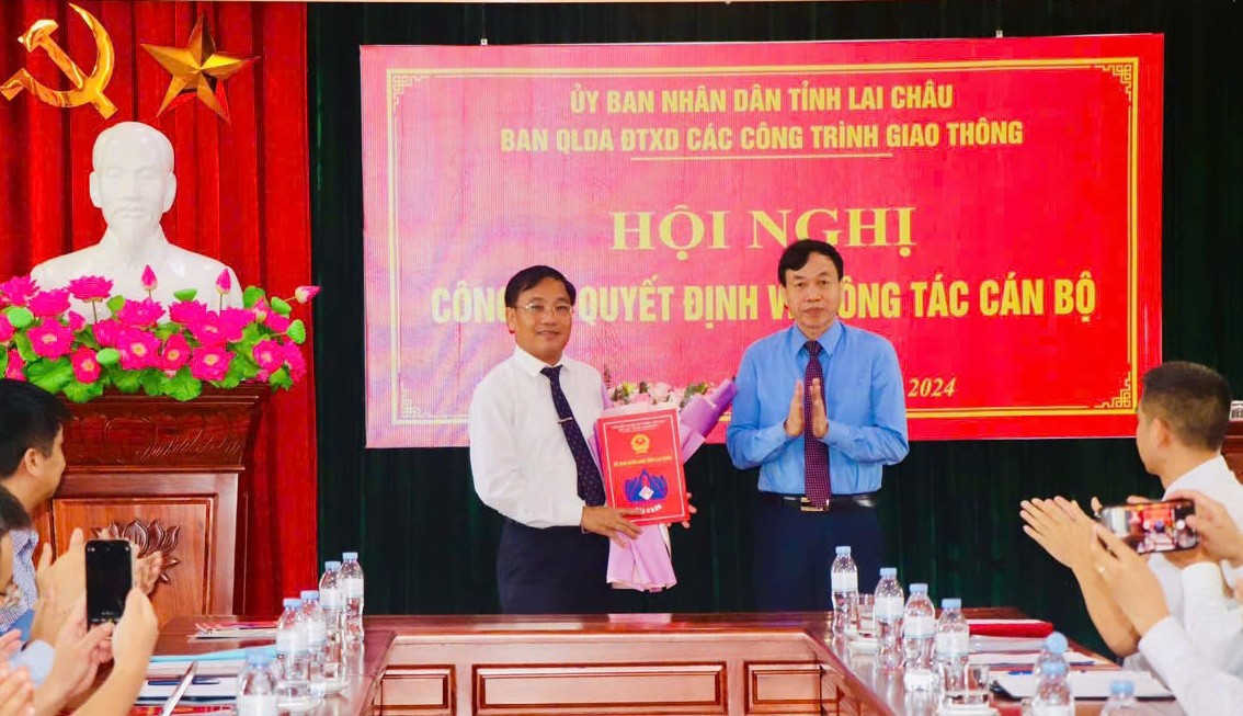 Chủ tịch UBND tỉnh Lai Châu Lê Văn Lương trao quyết định và tặng hoa chúc mừng tân Giám đốc Ban Quản lý Dự án Đầu tư xây dựng các công trình Giao thông Mai Khắc Phượng.