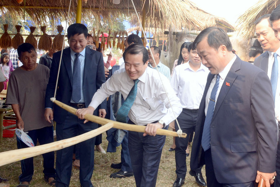 Các đại biểu trải nghiệm xay ngô truyền thống tại không gian văn hóa vùng cao.