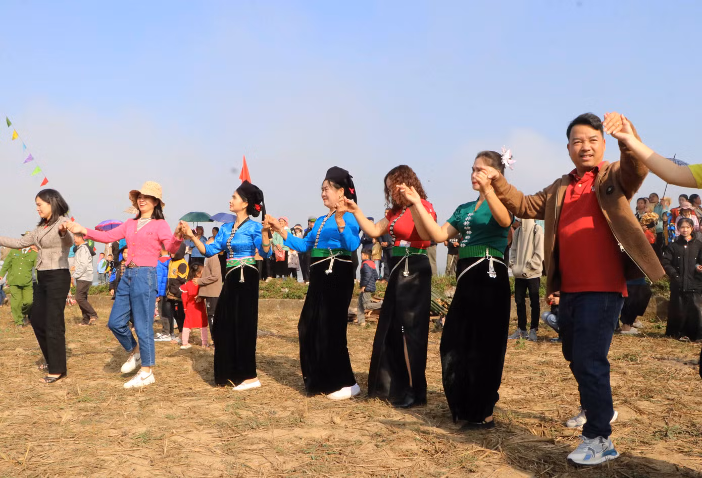 Nhân dân và du khách cùng nhau nắm tay tham gia vòng xòe đoàn kết tại Lễ hội Lùng Tùng của người Thái ở Than Uyên.