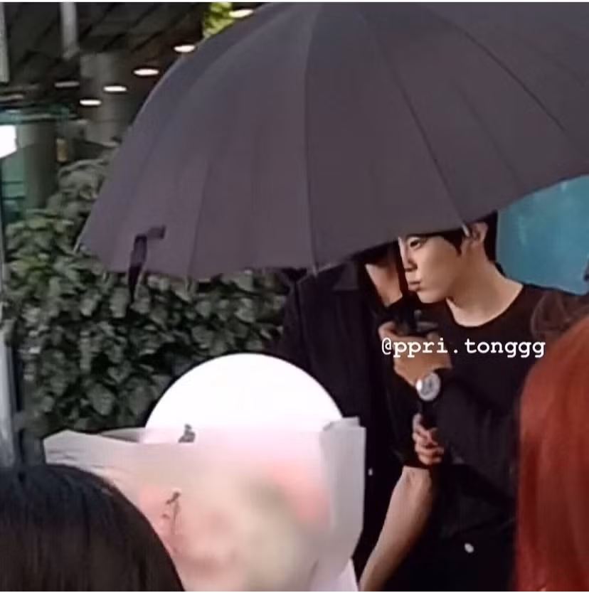 Kim Woo Seok trong trang phục đen tại sân bay. - Nguồn: ppri.tonggg