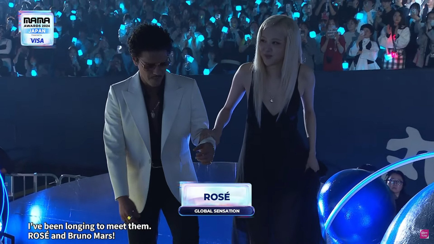 Bruno Mars đỡ Rosé khi cả hai tiến lên bục nhận giải. Bruno Mars đỡ Rosé khi cả hai tiến lên bục nhận giải.
