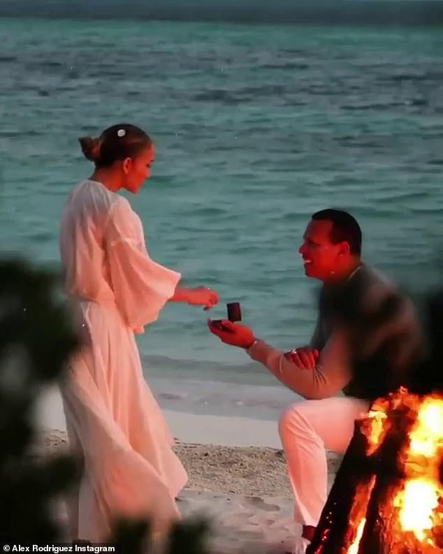 Jennifer Lopez và Alex Rodriguez chính thức hẹn hò từ năm 2017. Từ ngày bên nhau, hình ảnh &quot;tình bể bình&quot; của cả liên tục được chia sẻ trên báo chí, mạng xã hội khiến nhiều người ngưỡng mộ. Sau khoảng 2 năm yêu nhau, họ quyết định đính hôn hồi tháng 3/2019 nhưng vẫn chưa thể tổ chức đám cưới do dịch bệnh COVID-19. Ảnh: Jennifer Lopez được Alex Rodriguez quỳ gối cầu hôn trên bãi biển năm 2019.