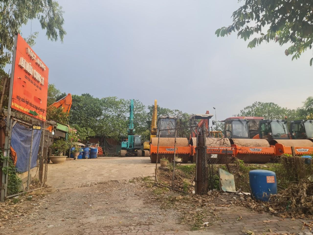 Cách đó không xa là bãi tập kết xe lu, xe ủi, máy xúc