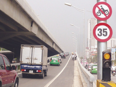 Có biển cấm nhưng xe ôm, người đi bộ vẫn vô tư lên xuống đường trên cao vừa mới thông xe. Ảnh: Trọng Đảng