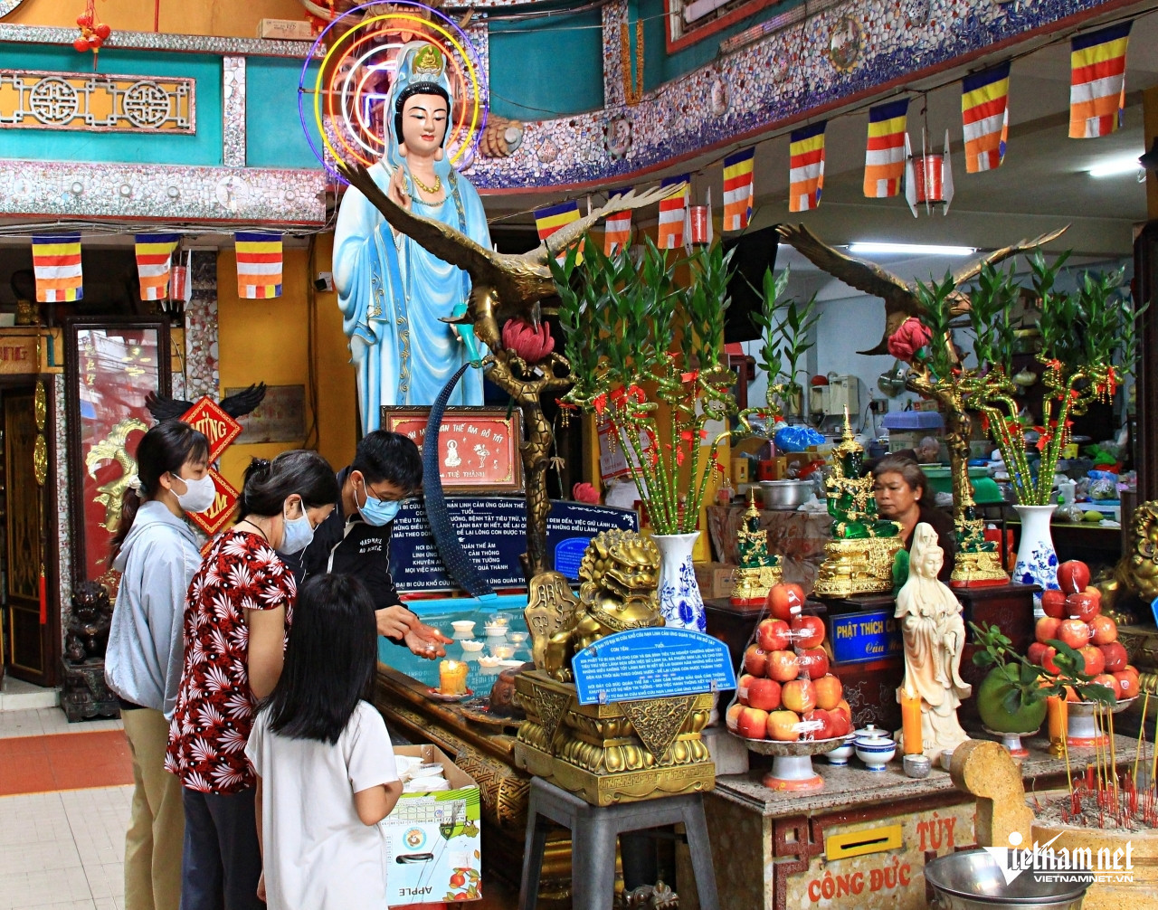 Nam thanh niên đốt, thả đèn hoa đăng xuống hồ nước nhân tạo sau khi khấn xin bình an trong cuộc sống. Ảnh: Hà Nguyễn