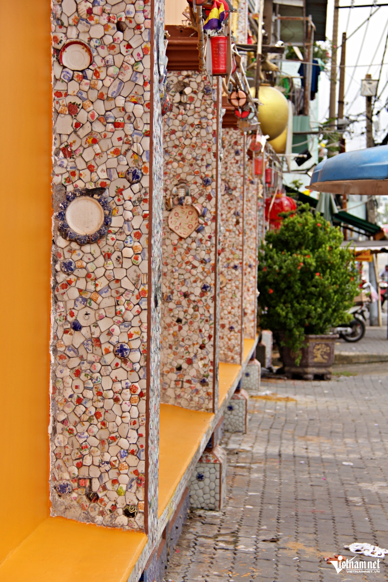 Ngay cả hàng cột bê tông bên ngoài tường rào cũng được chùa trang trí bằng các mảnh sành, sứ phế liệu. Ảnh: Hà Nguyễn