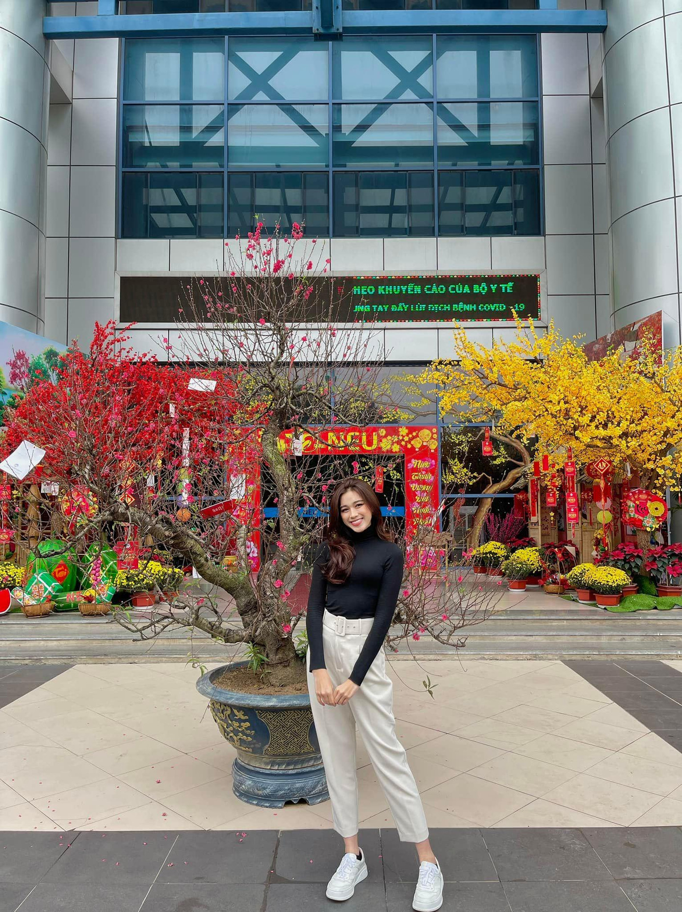 Người đẹp rạng rỡ khi khoe nhan sắc bên cây đào nở rực rỡ trong khuôn viên trường.