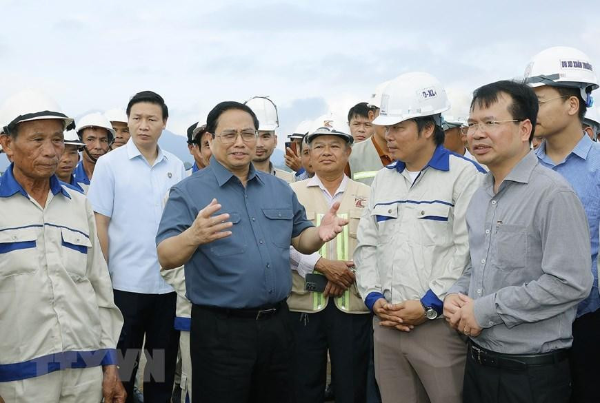 Thủ tướng Phạm Minh Chính nói chuyện với công nhân xây dựng dự án tuyến đường Đông-Tây giai đoạn 1 đoạn từ thành phố Tam Điệp đến huyện Nho Quan. (Ảnh: Dương Giang/TTXVN)