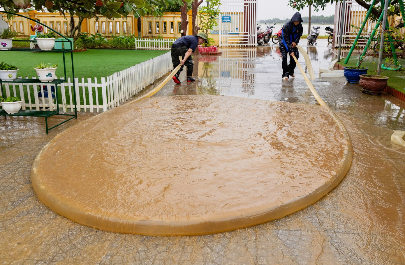 Một sáng tạo trong dọn bùn non, là dùng ống nhựa, bơm đầy nước, sau đó kéo lê trên sàn để lùa bùn non ra ngoài. Những người tham gia dọn lụt nói, cách lùa bùn non kiểu này nhanh hơn và tiết kiệm công sức hơn rất nhiều.