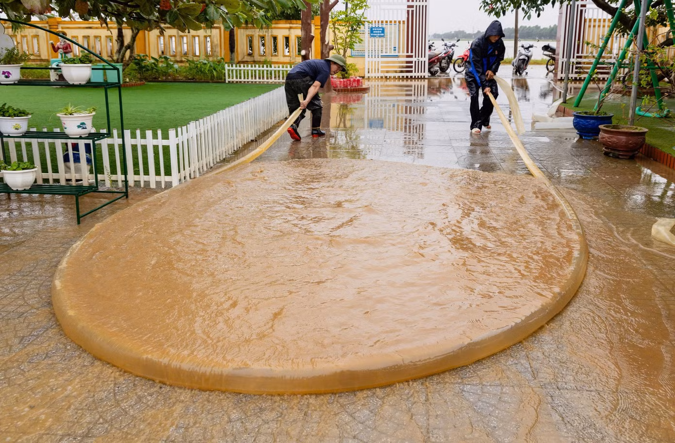 Một sáng tạo trong dọn bùn non, là dùng ống nhựa, bơm đầy nước, sau đó kéo lê trên sàn để lùa bùn non ra ngoài. Những người tham gia dọn lụt nói, cách lùa bùn non kiểu này nhanh hơn và tiết kiệm công sức hơn rất nhiều.