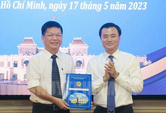 Phó Chủ tịch UBND TPHCM Bùi Xuân Cường trao quyết định cho ông Nguyễn Tương Minh (bìa trái). Ảnh: Thành ủy TPHCM.