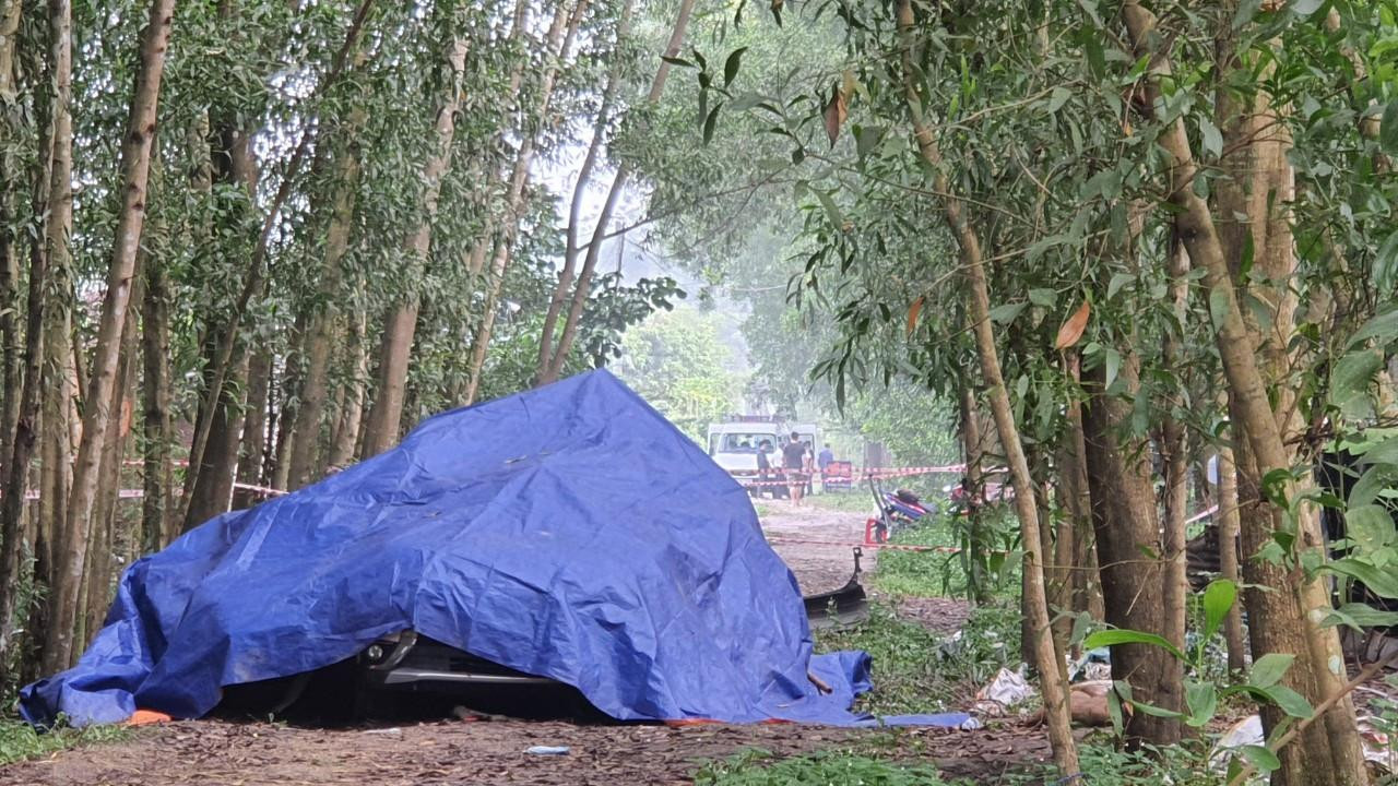 Ô tô nổ cháy được phủ bạt, bên ngoài có công an túc trực bảo vệ hiện trường Ô tô nổ cháy được phủ bạt, bên ngoài có công an túc trực bảo vệ hiện trường