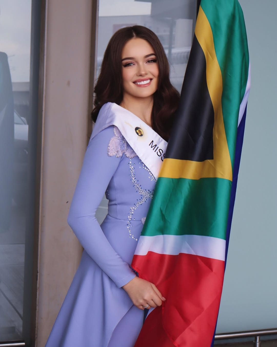 Đại diện Nam Phi - Zoalize Jansen Van Rensburg - mặc trang phục màu tím nữ tính khi ra sân bay. Cô 18 tuổi, có gương mặt ngọt ngào, vóc dáng gợi cảm. Zoalize đang làm giám đốc tiếp thị kỹ thuật số tại quê nhà.