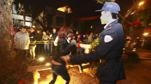 Một phụ nữ bị bảo vệ ngăn cản khi đang vượt hàng rào để chụp ảnh - Ảnh: Nguyễn Khánh 