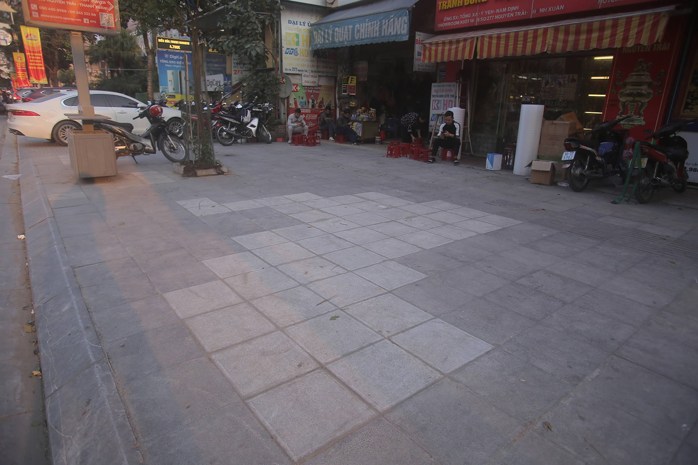 Một đoạn vỉa hè đường Nguyễn Trãi được lát lại. Theo đơn vị thi công, đá mới được lát có màu sáng hơn, nhưng sau thời gian sẽ đồng màu với đá cũ. Ảnh: Duy Phạm