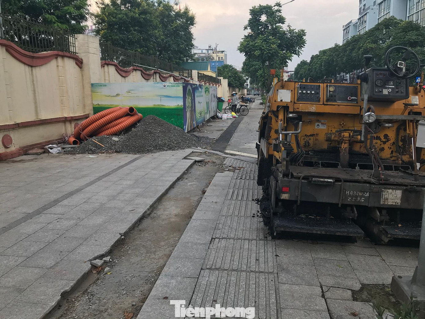 Bên cạnh khu vực vỉa hè và lòng đường bị cắt xén, lột đá; có xe trộn nhựa đường, vật liệu xây dựng và đường ống. Ảnh: Trường Phong