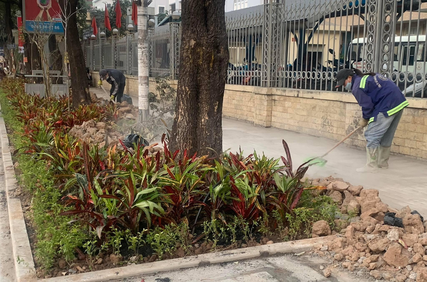 Các công nhân tiến hành quét dọn vỉa hè đầy đất thải trên phố Nguyễn Chí Thanh. Ảnh: Duy Phạm
