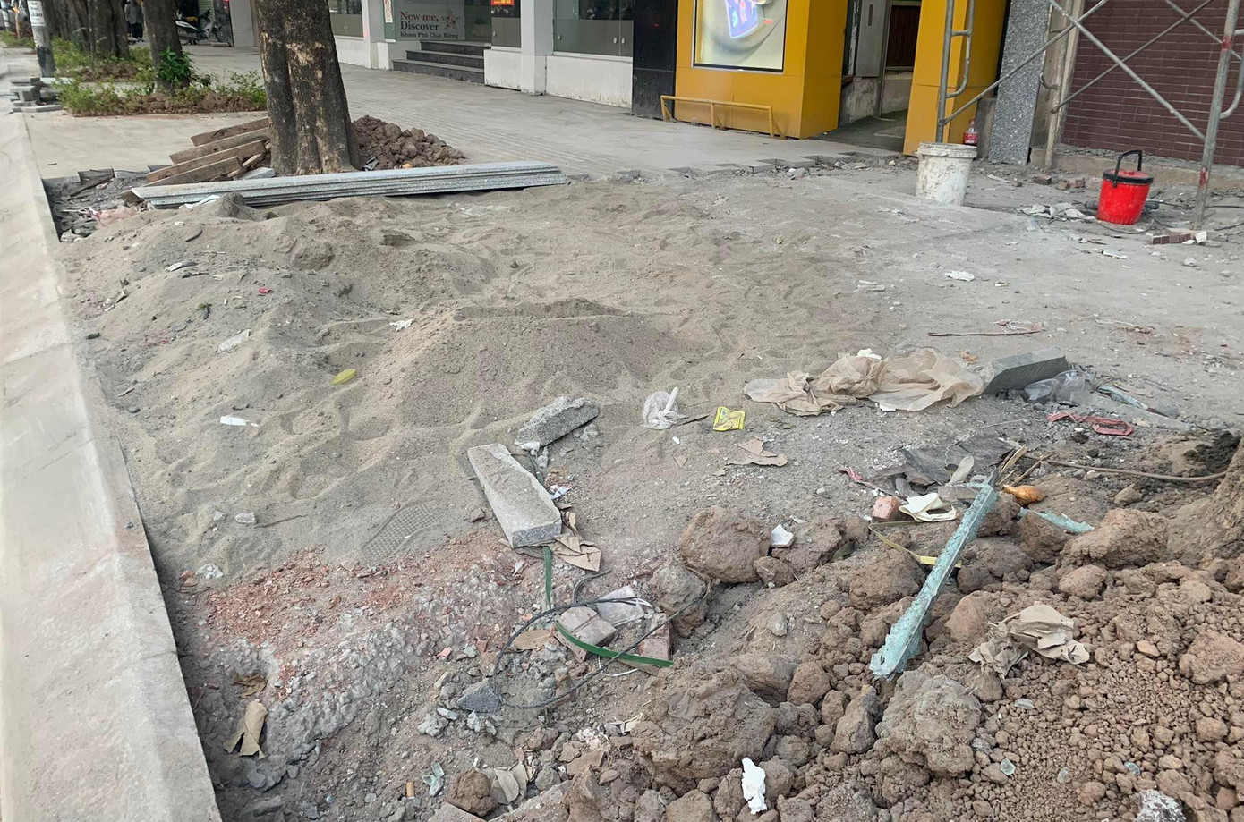 Vật liệu xây dựng lẫn với đất, rác trên vỉa hè tuyến phố Nguyễn Chí Thanh. Ảnh: Duy Phạm