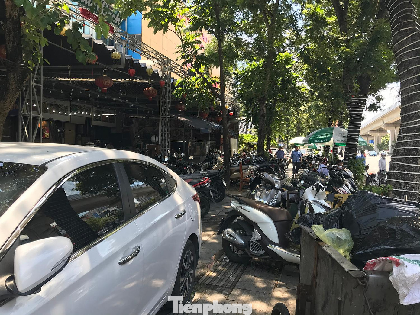 Theo ghi nhận của phóng viên Tiền Phong, tại nhiều tuyến phố trên địa bàn Hà Nội đã tái diễn tình trạng xe máy, ô tô lấn chiếm vỉa hè, lòng đường. Trong ảnh là xe máy, ô tô đỗ kín vỉa hè trước cửa một quán bia trên đường Nguyễn Trãi (quận Thanh Xuân). Ảnh: Trường Phong