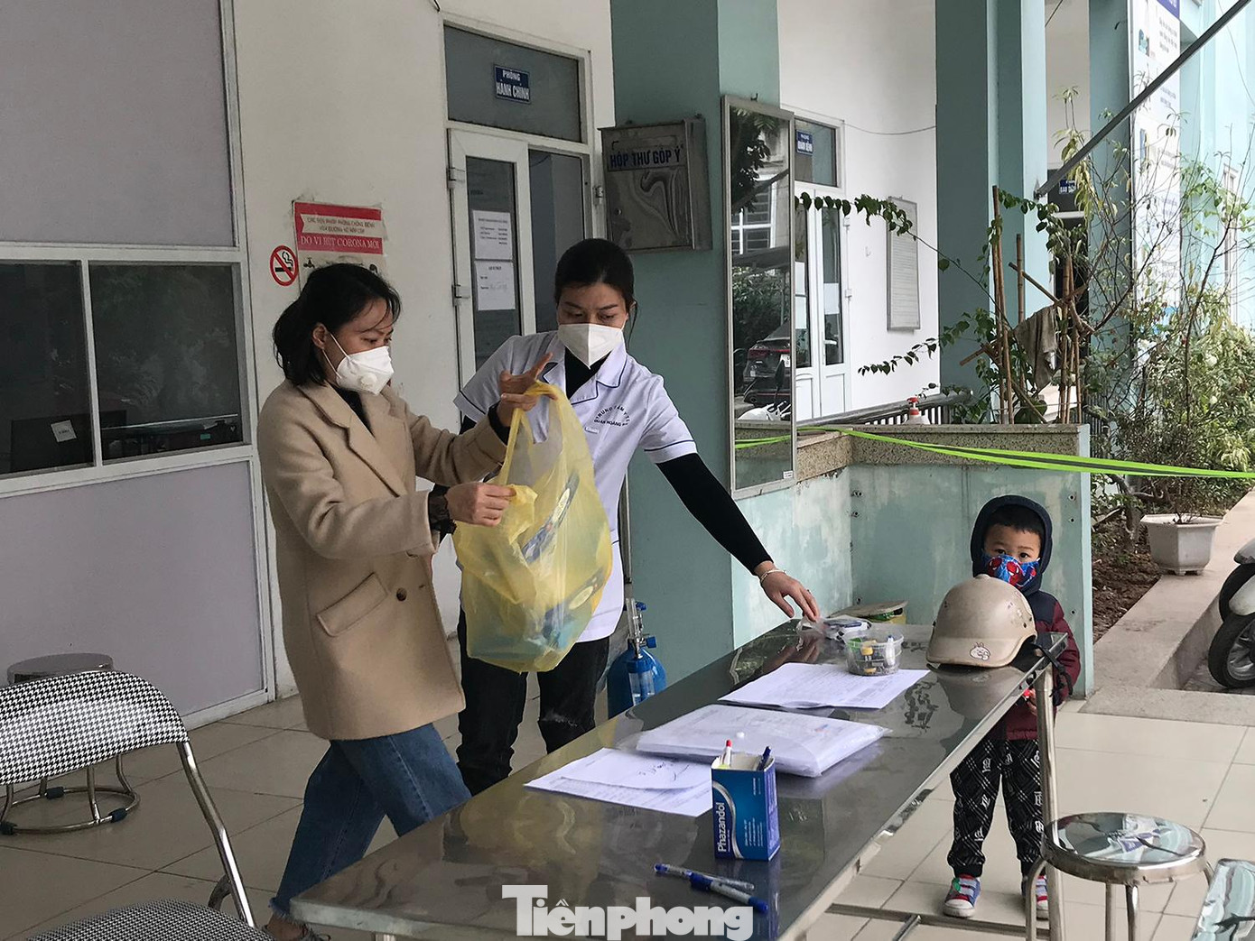 Cháu bé quanh quẩn trong Trạm Y tế phường khi mẹ và các cô chú làm việc.