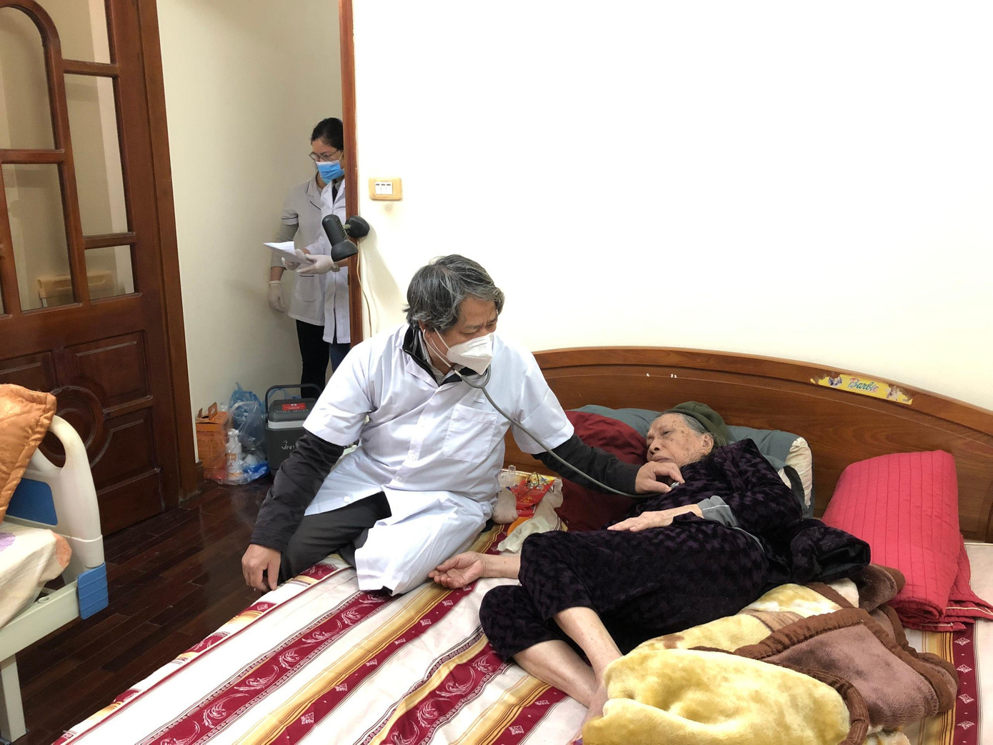 Trao đổi với phóng viên, đại diện lãnh đạo quận Ba Đình cho biết, công tác tiêm vắc xin COVID-19 cho những trường hợp già, yếu, nguy cơ cao không đến được điểm tiêm đảm bảo đúng quy định như khám sàng lọc trước khi tiêm, theo dõi sức khoẻ 30 phút sau tiêm. Quận phấn đấu hoàn thành công tác này trước 18h ngày Chủ nhật, 9/1/2022. Trong ảnh: Khám sàng lọc trước khi tiêm vắc xin COVID-19 cho người cao tuổi tại nhà trên địa bàn phường Vĩnh Phúc. Ảnh: PV