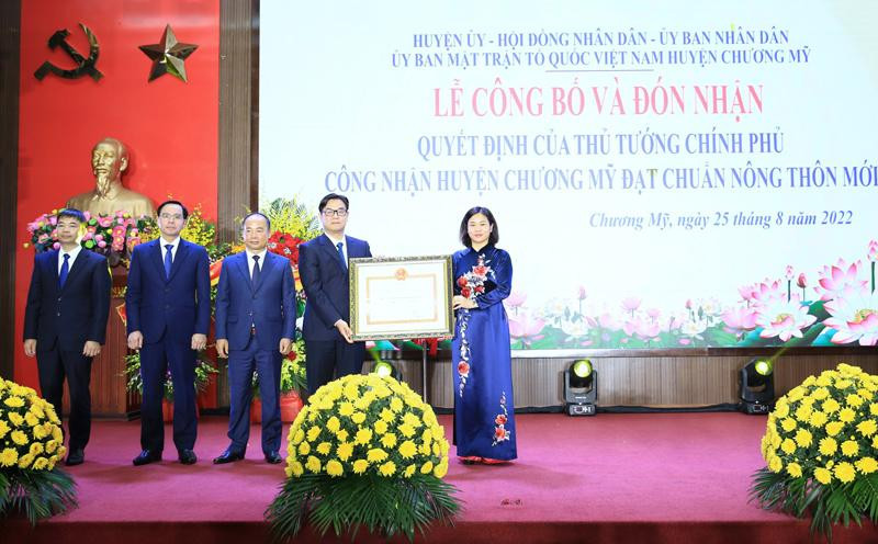 Phó Bí thư Thường trực Thành uỷ Hà Nội Nguyễn Thị Tuyến thừa uỷ quyền của Thủ tướng Chính phủ, trao Quyết định công nhận huyện Nông thôn mới cho đại diện lãnh đạo huyện Chương Mỹ. Ảnh: PV
