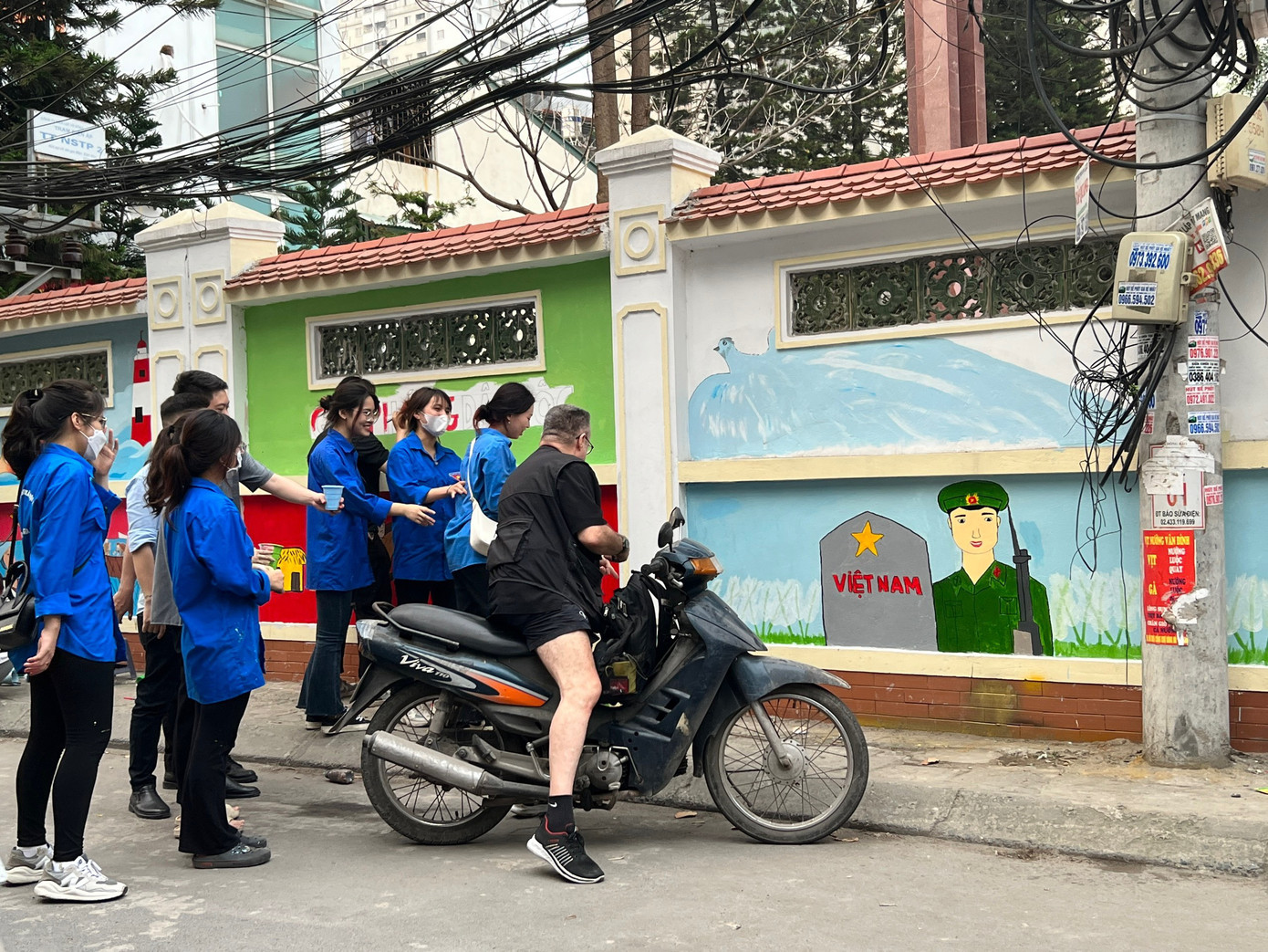 Màu áo xanh và màu sắc rực rỡ của công trình thu hút sự quan tâm của người qua lại.