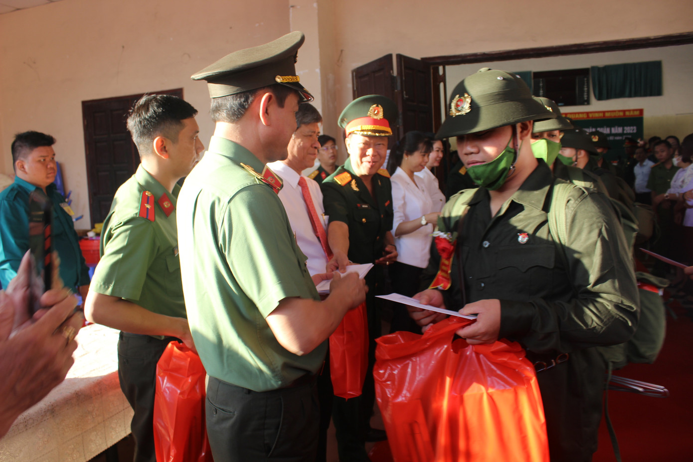 Lãnh đạo địa phương và lãnh đạo các đơn vị trao quà động viên tân binh trước khi lên đường.