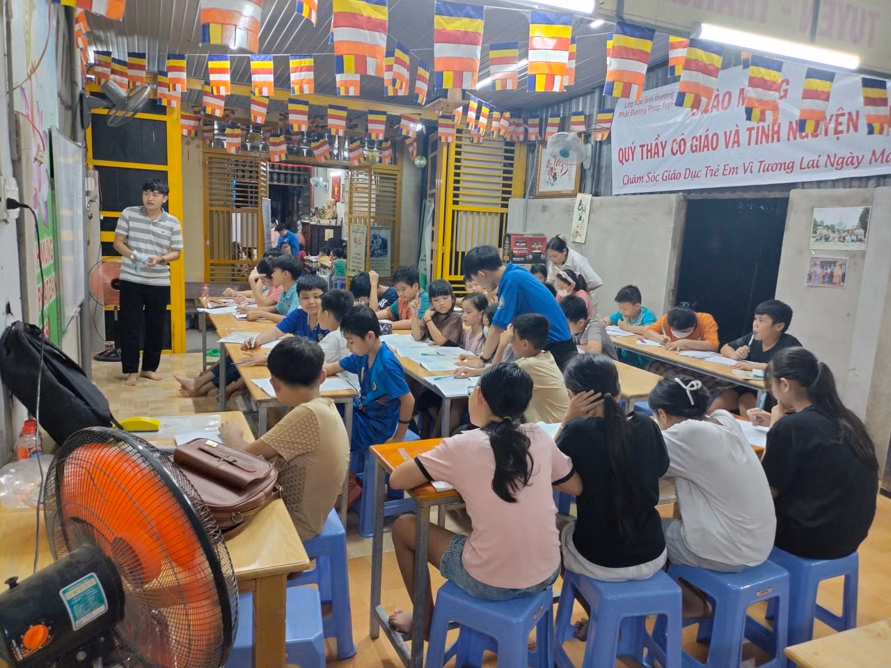 Những thanh niên tình nguyện mang màu áo xanh quen thuộc đến tận nơi để hỗ trợ, phổ cập kiến thức cho các em nhỏ tại chùa.