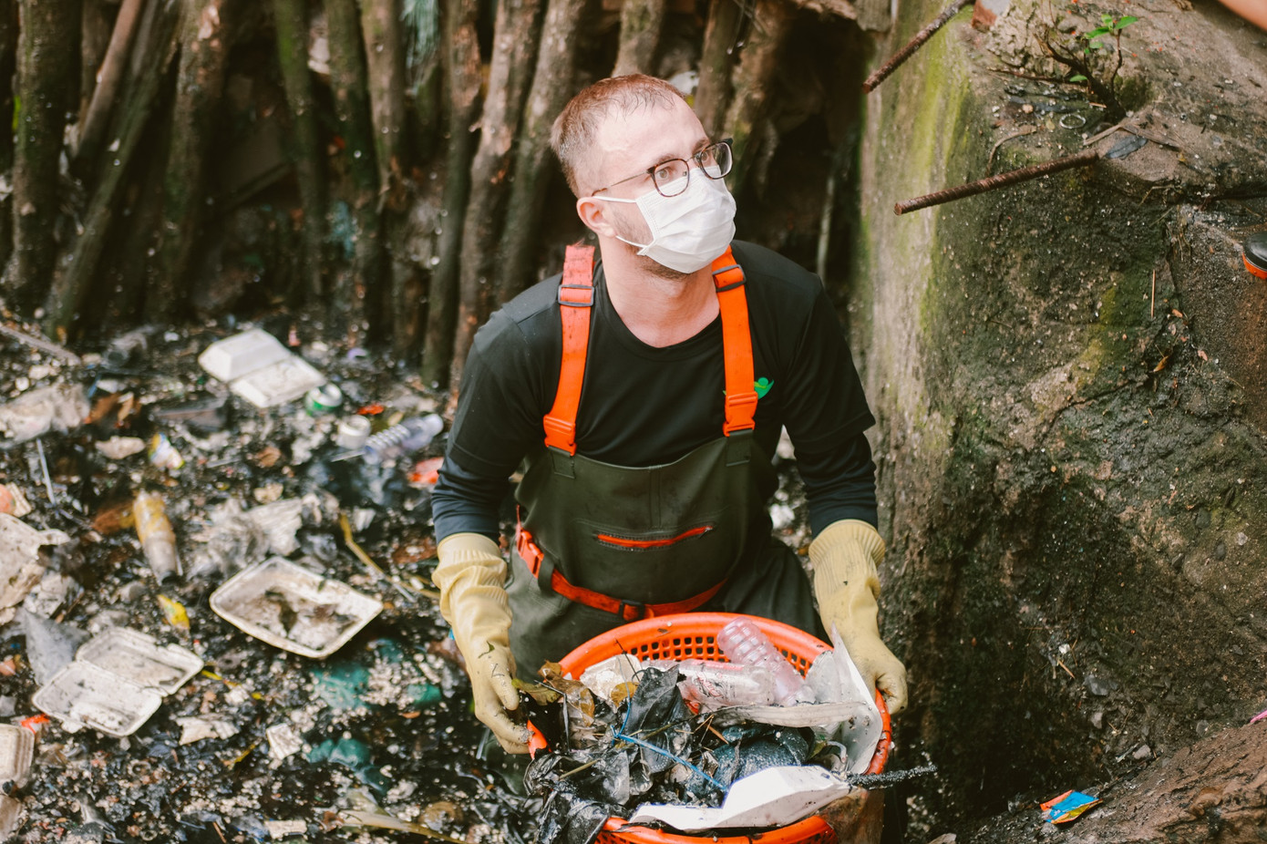 Một người nước ngoài phụ nhóm vớt rác. Một người nước ngoài phụ nhóm vớt rác.