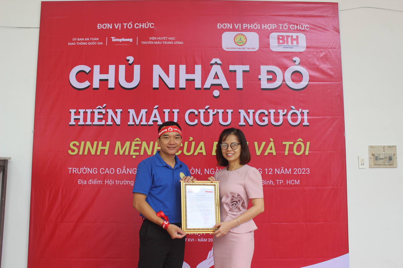 Chị Đặng Thụy Đông Nghi (bên phải) - đại diện báo Tiền Phong trao thư cảm ơn đối với đơn vị phối hợp thực hiện chương trình Trường CĐ Đại Việt Sài Gòn.