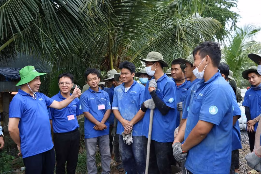 PGS. TS Vũ Hải Quân thăm sinh viên trường ĐH Bách khoa đang thi công đường tại xã Tân Hộ Cơ, huyện Tân Hồng. (Ảnh: ĐHQG TP. HCM)