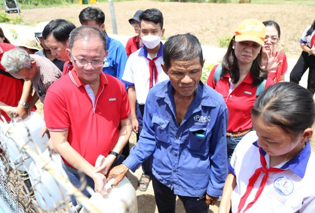 Đông đảo bà con xã Phú Đông và các xã lân cận đến lấy nước từ hệ thống máy lọc lắp tại Nhà văn hóa xã Phú Đông.