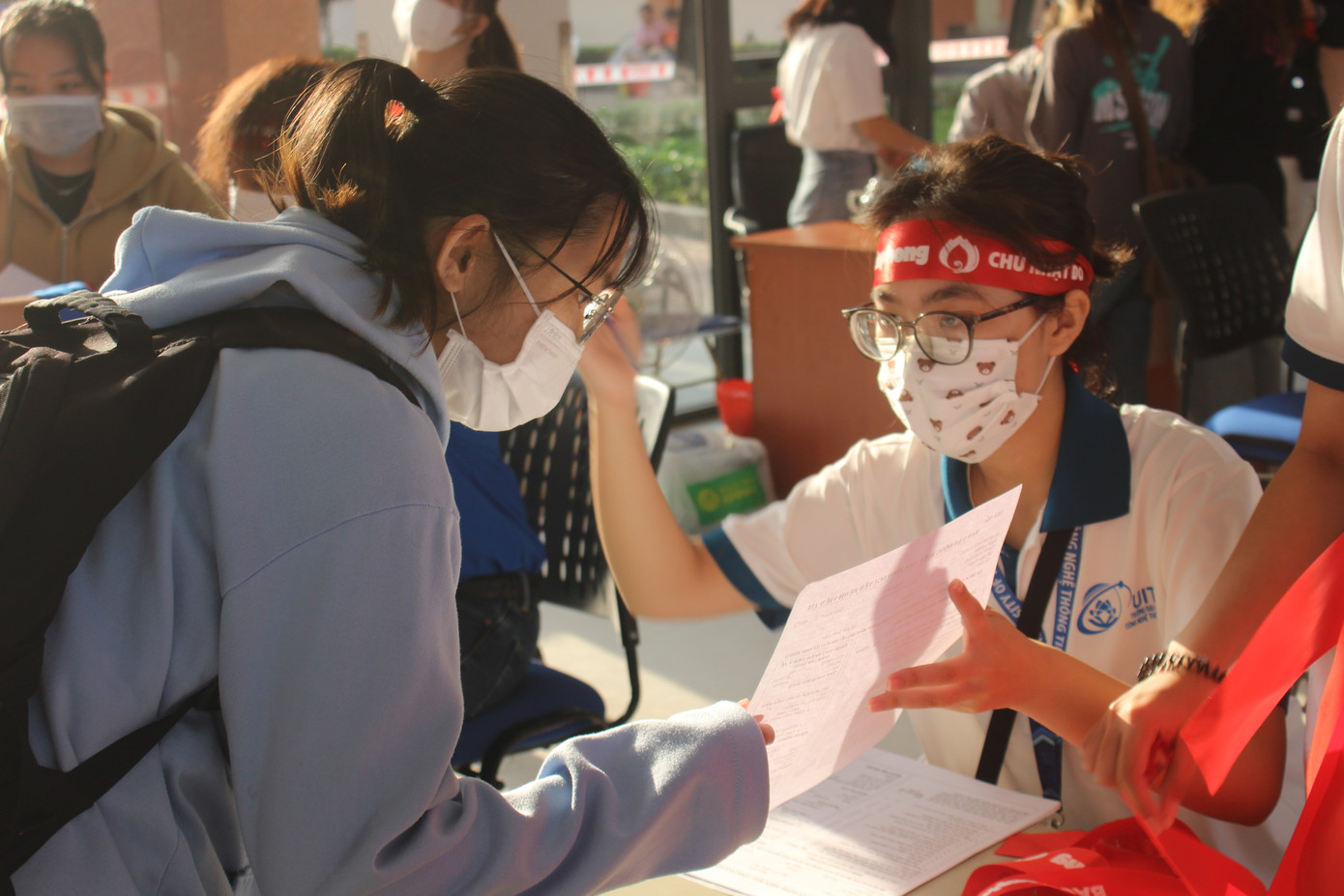 Các tình nguyện viên của chương trình hỗ trợ các bạn sinh viên điền phiếu thông tin.