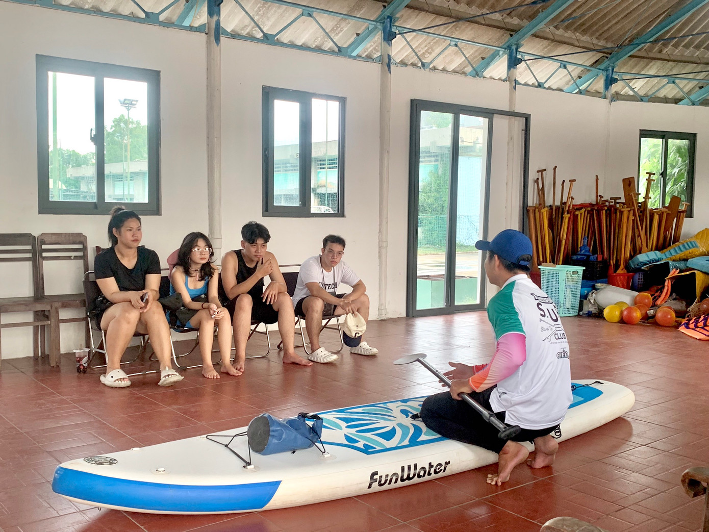 Huấn luyện viên hướng dẫn người tham gia các kỹ thuật chèo SUP trên cạn. Huấn luyện viên hướng dẫn người tham gia các kỹ thuật chèo SUP trên cạn.