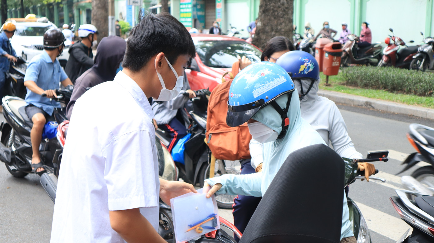 Phụ huynh chở con đến điểm thi dù bận nhiều công việc.