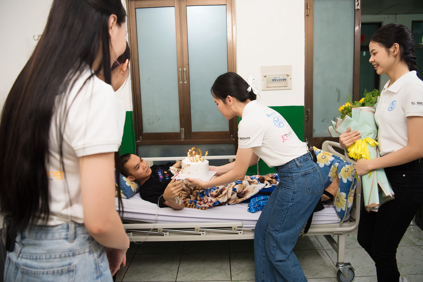 Các thí sinh Hoa hậu Thế giới Việt Nam trao quà cho những bệnh nhân khó khăn.