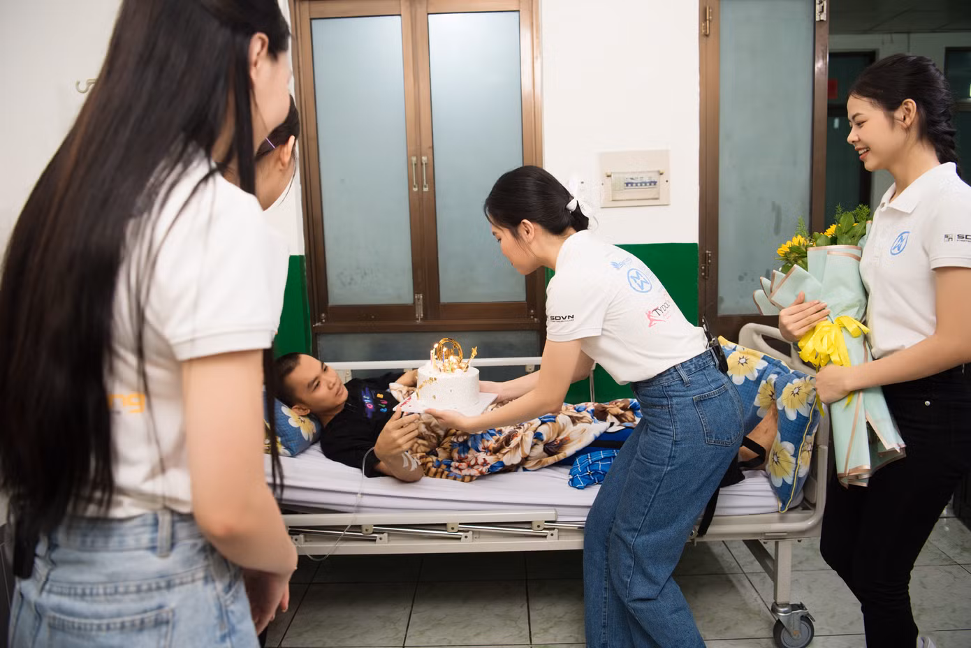 Các thí sinh Hoa hậu Thế giới Việt Nam trao quà cho những bệnh nhân khó khăn.