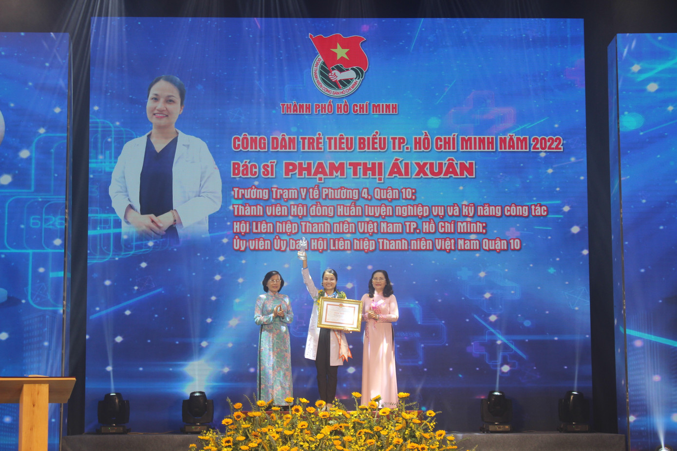 Bác sĩ Phạm Thị Ái Xuân, Trưởng Trạm Y tế phường 4, quận 10; Thành viên Ủy ban Hội Liên hiệp Thanh niên Việt Nam quận 10 nhận hoa và bằng khen tại lễ tuyên dương.