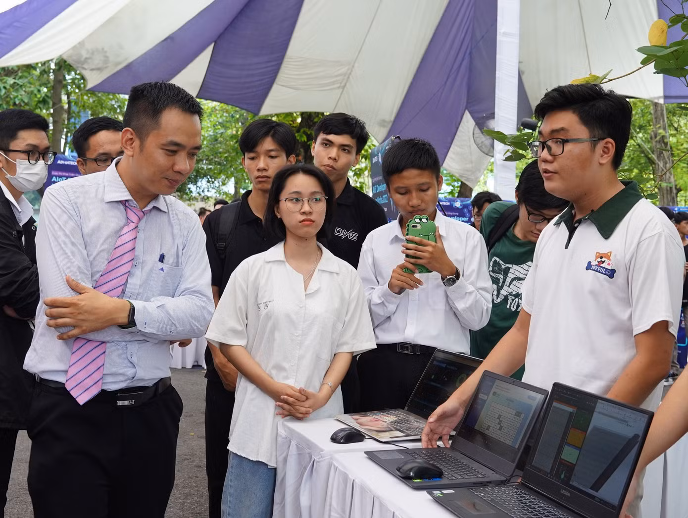 Một đội thi chia sẻ về dự án của mình với khách tham quan tại triển lãm vòng Chung kết cuộc thi. (Ảnh: ĐHBK)