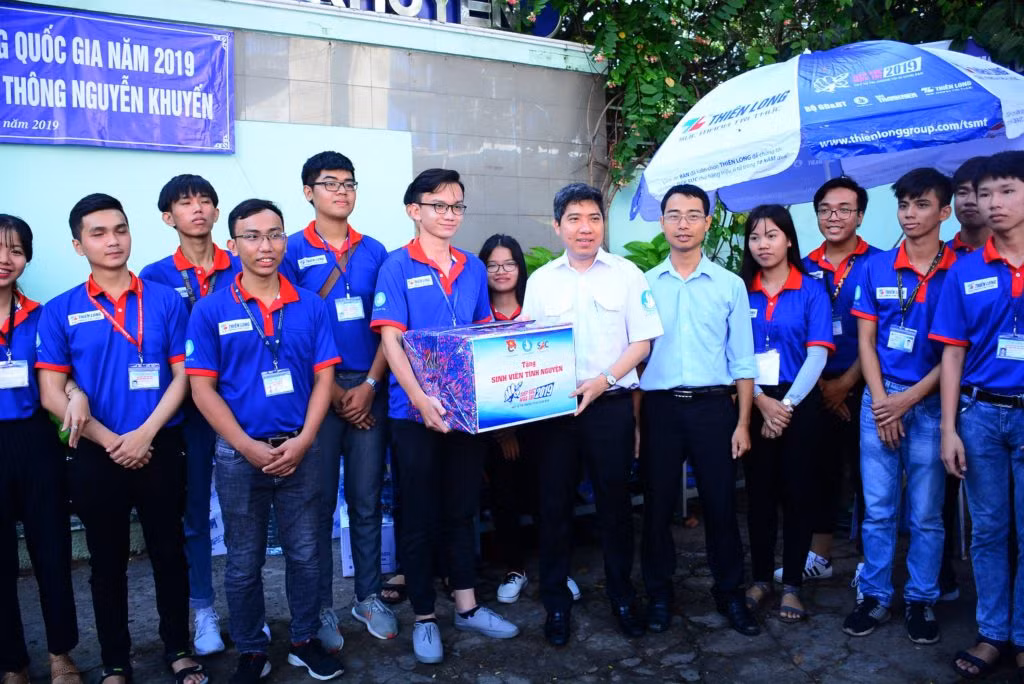 Anh Lê Xuân Dũng - Giám đốc Trung tâm Hỗ trợ học sinh, sinh viên TP. HCM (thứ năm, từ phải sang) trong hoạt động thăm, động viên các bạn sinh viên tình nguyện trong chương trình "Tiếp sức mùa thi" tại TP. HCM. (Ảnh: TLTĐ)