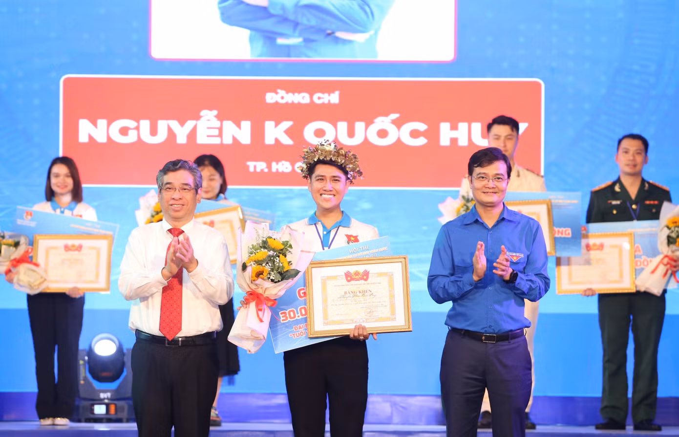 Anh Bùi Quang Huy - Ủy viên dự khuyết T.Ư Đảng, Bí thư thứ nhất T.Ư Đoàn và ông Nguyễn Phước Lộc - Phó Bí thư Thành ủy TP. HCM trao Bằng khen và hoa cho thí sinh Nguyễn Khắc Quốc Huy. (Ảnh: Ngô Tùng)
