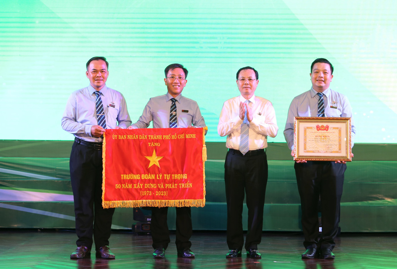 Ông Nguyễn Văn Hiếu, Phó Bí thư Thành ủy TP. HCM (thứ hai, từ phải sang) tặng Cờ của UBND TP. HCM cho Trường Đoàn Lý Tự Trọng. (Ảnh: Ngô Tùng)