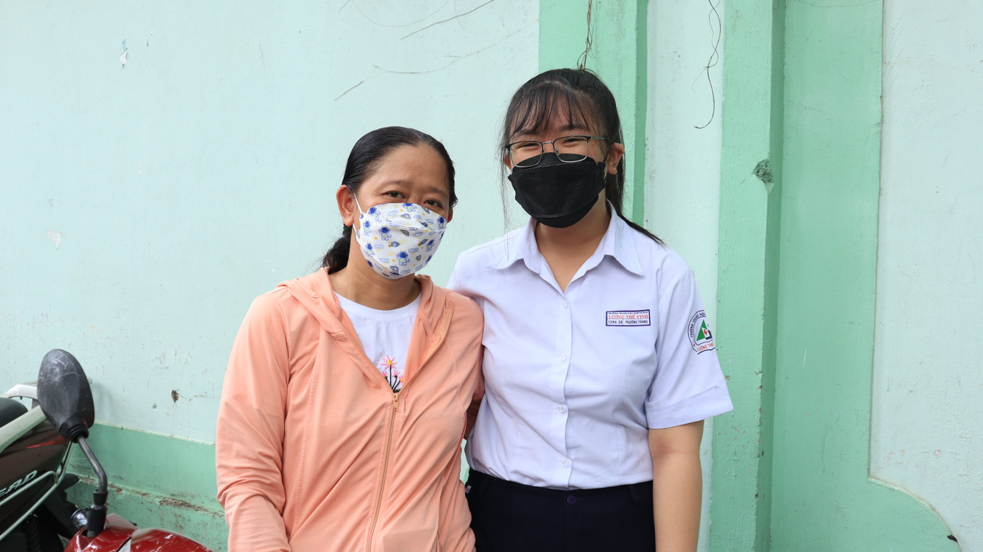 Chị Phương Thảo cùng con gái của mình tại điểm thi trường THCS Võ Trường Toản, TP. HCM.